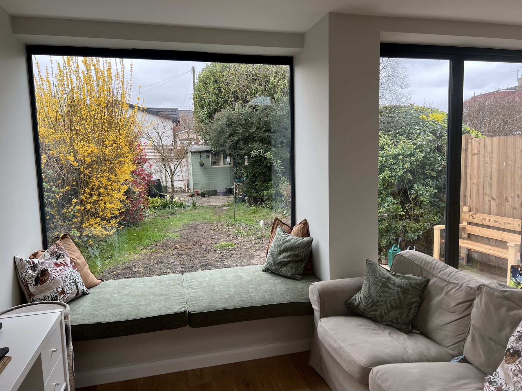 A finished picture window and built-in window seat looking onto the garden